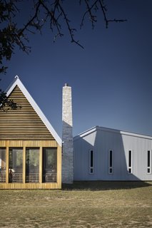 The tapered limestone chimney draws inspiration from an existing shed built of dry-stacked local stone.