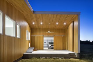 Sliding barn doors connect the garage to a shaded outdoor sculptural studio that doubles as a stage for summer concerts.