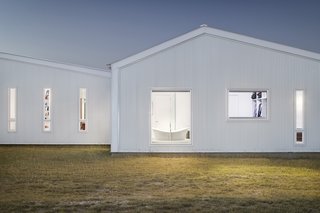 White corrugated-aluminum siding and a standing-seam metal roof have been chosen for the exterior, as these materials are known for having a long lifespan and require low maintenance.