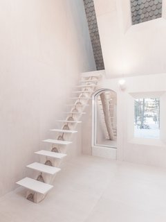 The use of mirrors, natural materials, and the sloped wall covered in shingles give the sense of indoor/outdoor living all throughout the home.