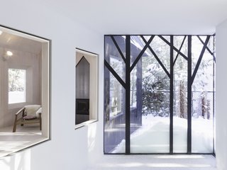 The tree-shaped window frames bring an abstract forest indoors.