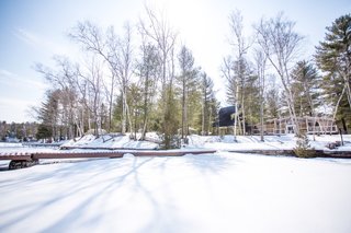 A view of the cabin from the frozen lake. Here, the existing property can be seen to the right of the cabin.
