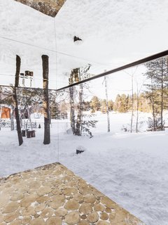 The outdoor terrace features cedar log-end flooring, while the underside of the roof is covered with mirrored panels.