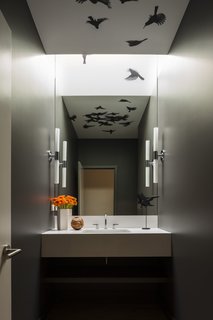 "The owners have a love of blackbirds and had coveted this Indi wallpaper from Trove for years," add the architects. "The design team came up with the idea of applying it to the ceiling and wrapping it into the continuous skylight so the illusion of birds flying through could come to life. All who enter the room are surprised by the birds reflected in the mirror."