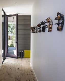 The entrance hallway is lined with a series of vintage baseball catcher's masks, dating from the 1920s to 50s.