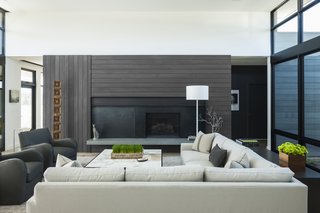 The fireplace wall features custom-fabricated blackened steel with a sliding panel that can conceal the television when not in use.