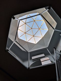 A clear geodesic dome tops the structure, and floods the interior with natural light.