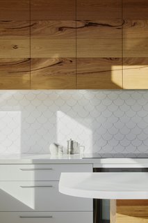 Dainty scallop tiles cover the kitchen backsplash.