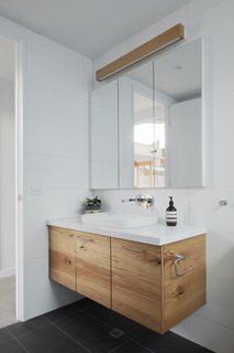 Caesarstone countertops (Ocean Foam) in the bathroom complement the tiled walls and flooring.