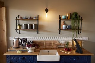 A white, hexagonal tile backsplash adds a modern touch to the upcycled 19th-century oak sideboard.