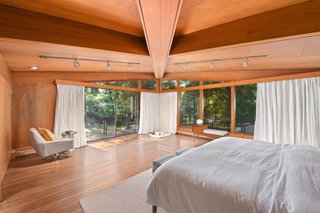 Sliding glass doors connect the master suite to the wraparound deck.