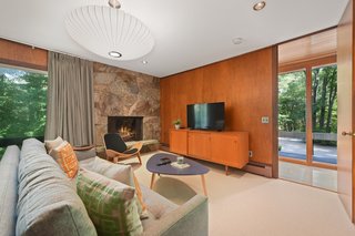 The den comes with a stone fireplace and doors to the balcony.