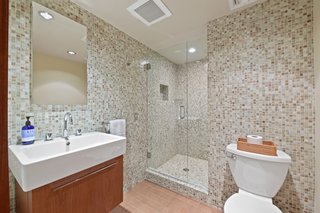 The ensuite bath features tiled walls and a glass-enclosed shower.