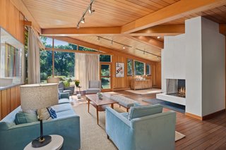 A fireplace is located in the middle of the L-shaped great room.