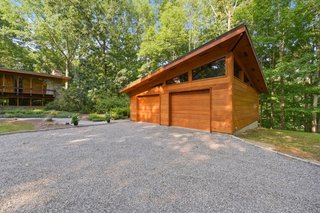 A long, paved driveway leads to a gravel circle, lined in Belgian block, and a two-car detached garage.