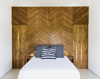 The chevron pattern is brought indoors to the bedrooms. Pivoting doors on either side of the bed provide access to the bathroom.