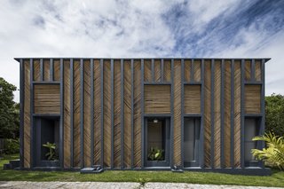 Concrete masonry blocks were used for the main volume. The vertical ribs of the concrete frame were painted dark blue—a color referencing the Mediterranean—and fitted with bamboo panels arranged in a chevron pattern.