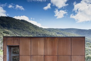 Bespoke Cor-Ten cladding wraps around the home to meet local bushfire regulations.