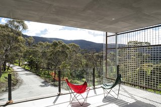 A deep roof overhang creates a sheltered outdoor patio for enjoying north-facing views of the landscape.