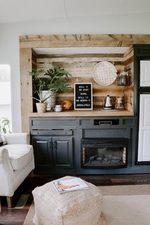 The couple removed the upper cabinets, repainted the lower cabinets, and inserted hardwood flooring, along with a new butch-block countertop.