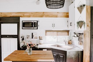 The kitchen counter was repainted with Giani Faux Granite paint and the lower cabinets were repainted with Sherman Williams Iron Ore. A new butcher-block now tops the kitchen island.