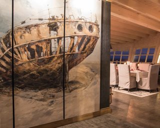 An artwork of a shipwreck hangs next to the dining room.