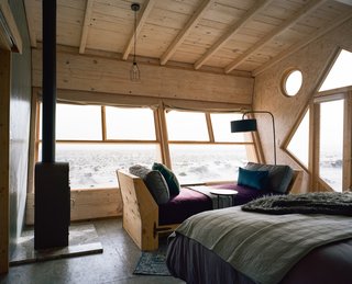 The beds face a large horizontal window that overlook views of the sea and the sunset.