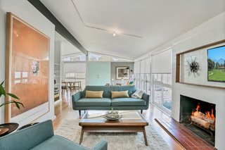 The living space is anchored by a wood-burning fireplace with a white-painted brick surround.