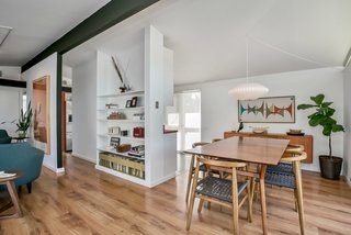 A dining table to the right of entryway sits close to the kitchen tucked behind the wall.