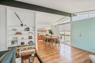 The house ridge beam is painted black and flanked by clerestory windows above the main entrance.