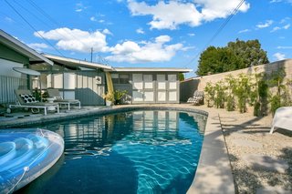 A lagoon-style pool sits to the south side of the house. Tall cinderblock walls provide privacy.