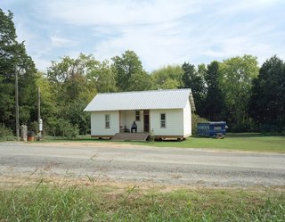 MacArthur’s Home is a one-bedroom, one-bathroom house with a central front porch flanked by living and bedroom wings. It was the ninth 20K House completed.