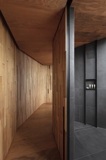 The bathroom features a spacious walk-in shower lined in charcoal porcelain tiles.