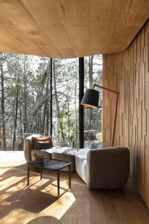 The landscape-inspired interior features a simple color palette of grays, oranges, and blues.