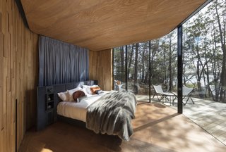Curved, full-height glazing erases the boundary between indoors and out. 