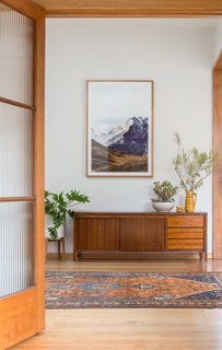 A view from the lounge into the converted study furnished with a vintage midcentury sideboard.