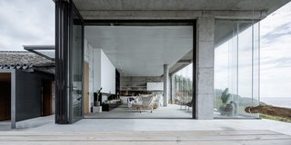 A massive folding glass wall opens to connect an open-plan living area to the outdoors.
