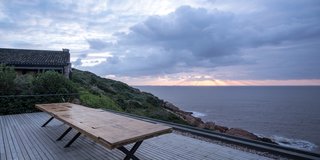 The wooden rooftop deck is edged with river stone.