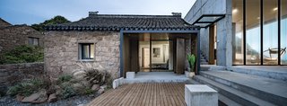 The smaller of the two existing buildings, this renovated structure houses two bedrooms. A glass overhang was installed above the passageway linking the historic structure with the concrete addition.