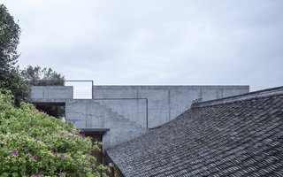 Concrete steps lead up to the concrete's extension's roof deck and also connects to the courtyard of the second building.