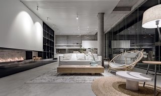 Seen at night, the sumptuous living area features modern furnishings and a long wood-burning fireplace.