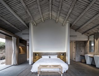 A timber beamed ceiling adds a rustic touch to the modern master suite.