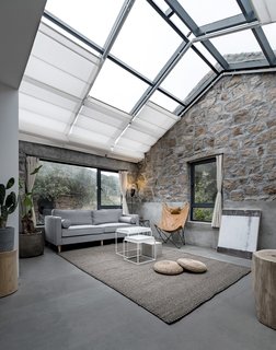 Formerly used as a kitchen, the space next to the master bedroom has been turned into a living area. Retractable shades cover the glazed ceiling and are remotely controlled.