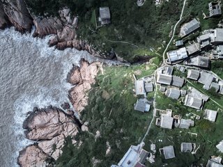 The buildings are set close to the edge of the weathered cliffs on the east side of Dahuanglong, an island in Zhejiang, a province located southeast from Shanghai.