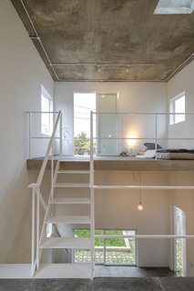 The bedroom is located on the uppermost level that connects to a small outdoor balcony.