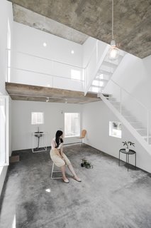 The floors are built of exposed concrete, while the brick walls have been painted white.