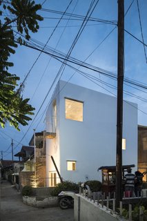 Windows of varying sizes punctuate the building, giving it a sculptural appearance.