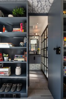 The entrance to the bathroom is tucked between two bookshelves.