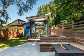 Concrete pavers line the new hardscape, which steps up to a deck built of ipe wood. Ipe wood has also been used for the built-in benches and fencing.