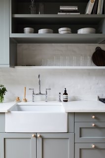 The kitchen countertops and shallow shelf are Olympian White Danby marble. The white oak cabinet knobs are from Etsy.